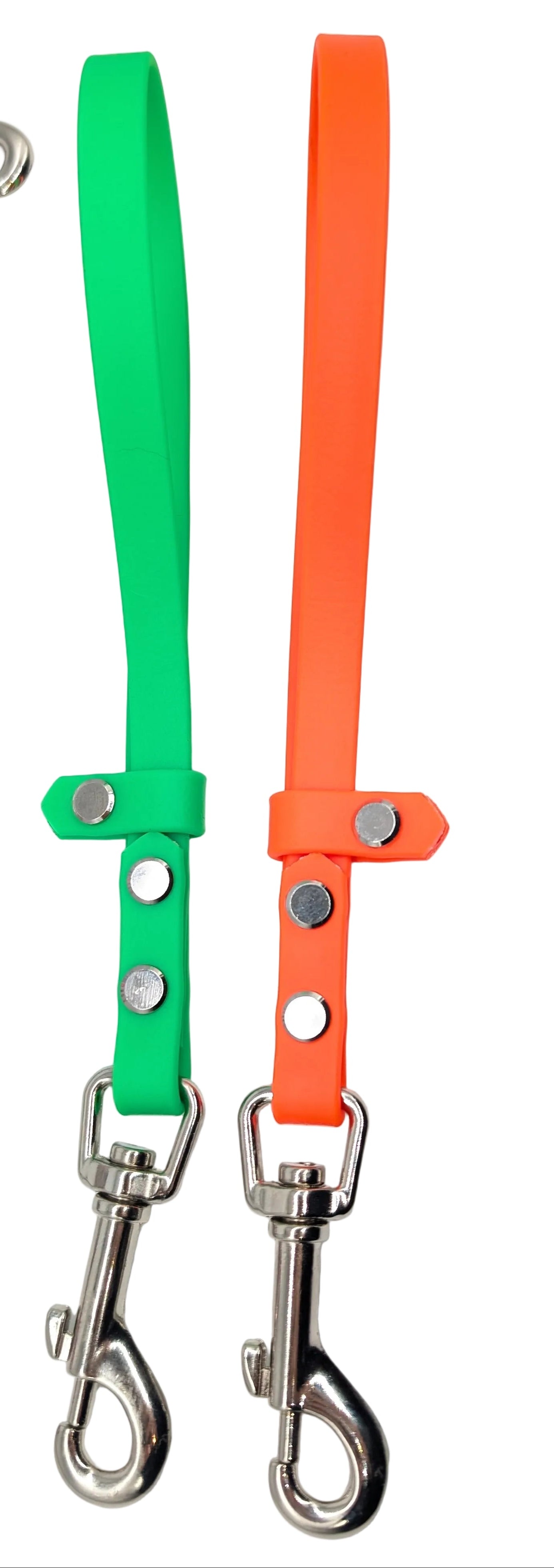 Two dog leashes, one green and one orange, with metal clasps on a white background.